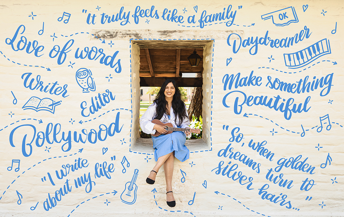 Nikhita Panjnani sitting in adobe windowsill in blue dress. On the white adobe walls surrounding her are light blue illustrations of the phrases: "Love of words" "Writer" "Editor" "Bollywood “I write about my life” "Daydreamer" "Make something beautiful" “So, when golden dreams turn to silver hairs…” and the following objects: Owl, Guitar, and the State of Oklahoma