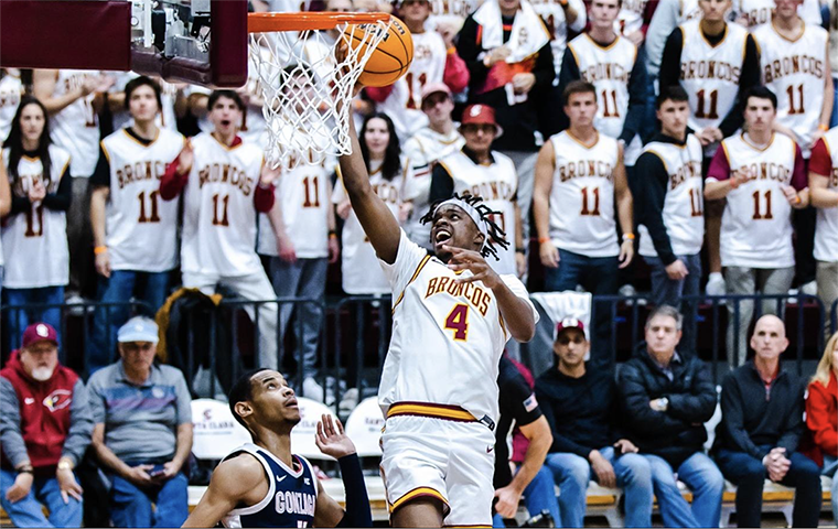 Adama-Alpha Bal lays in the ball against Gonzaga. Fans wearing #11 Nash jerseys fill the stands behind him.