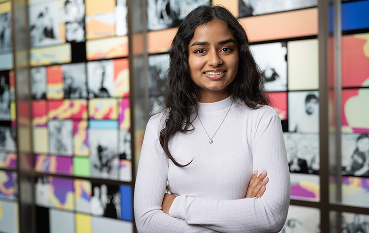 Neha Mann standing in front of a multicolored glass display